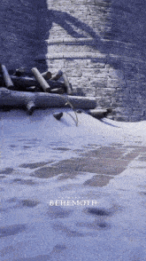 a brick wall with a pile of logs and the word benemoth on the ground