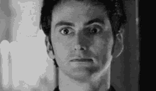 a close up of a man 's face with a surprised look on his face .