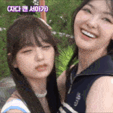 a couple of girls are standing next to each other and smiling for the camera .