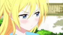 a close up of a yellow haired anime girl with blue eyes .
