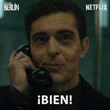 a man is smiling while talking on a phone with a netflix logo in the corner