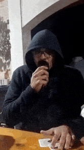 a man in a black hoodie with the word raven on the front