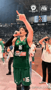 a basketball player in a green jersey with the number 16 on it