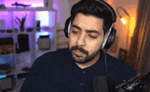 a man with a beard is wearing headphones and looking at the camera
