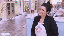 a woman is wearing an apron that says bake off on it
