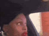 a woman is sitting in the back seat of a car with a red lipstick on her lips .