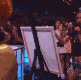 a woman with orange hair is singing into a microphone on stage