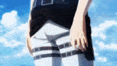 a person is standing in front of a blue sky with a belt around their waist .