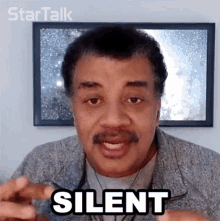 a man with a mustache is making a silent gesture
