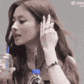 a woman is holding a bottle of water and a straw
