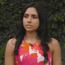 a woman is wearing a pink and orange dress