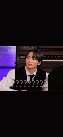 a young man wearing a black vest and white shirt is making a funny face with the words ?