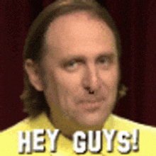 a man is wearing a yellow shirt and says hey guys .