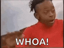 a young boy in a red shirt is making a funny face and saying whoa .