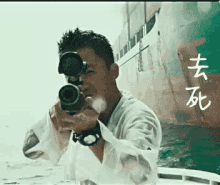 a man is holding a rifle in front of a ship with chinese writing on it .