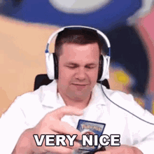 a man wearing headphones is holding a pokemon card and saying very nice .