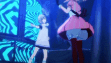 a couple of anime characters are dancing on a stage in front of a blue background .