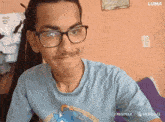 a young man wearing glasses and a blue shirt with a sonic the hedgehog on it