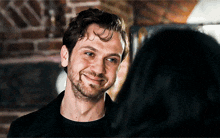a man with a beard smiles at a woman