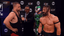 two wrestlers are standing in front of a wall with aew written on it