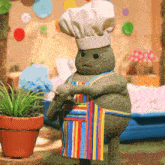 a stuffed frog wearing a chef hat and apron