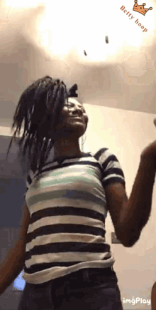 a woman in a striped shirt is dancing with the words belly boop on the bottom left
