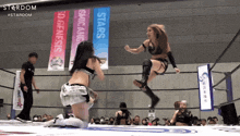 a woman in a wrestling ring with banners that say stars and genesis
