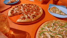 several pizzas are sitting on a table with a box that says caesars