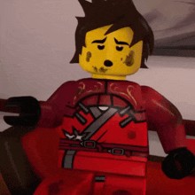 a lego figure with a dirty face and a red robe