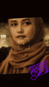 a woman wearing a hijab is being recorded on a camera with a busy stamp on the bottom