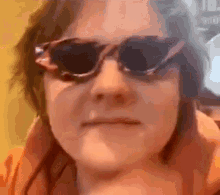 a close up of a person wearing sunglasses making a face .