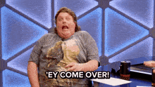 a man sitting at a table with the words ' ey come over ' on the bottom