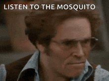 a close up of a man 's face with the words listen to the mosquito written on it .