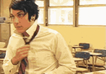 a man in a white shirt and tie is adjusting his tie