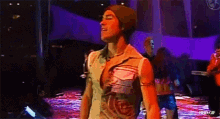 a man wearing a beanie is standing on a stage in front of a group of people .