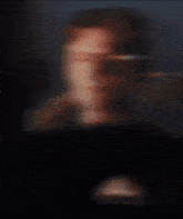 a blurry picture of a person 's face with the word adidas on the shirt