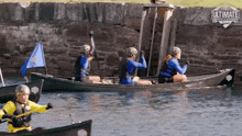 a group of people in canoes with the word ultimate on the bottom left