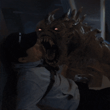 a man in a baseball cap looks at a monster with glowing eyes