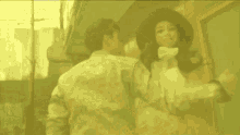 a man in a plaid shirt is standing next to a woman in a hat