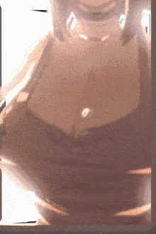 a blurred image of a woman 's chest with a necklace