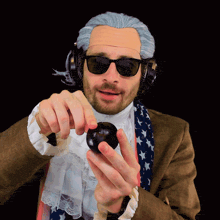 a man in a wig and sunglasses holds a black ball