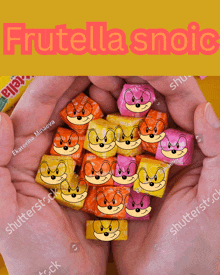 a hand is holding a pile of fruitella candy