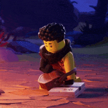 a lego man is playing a guitar while sitting on the ground