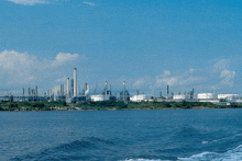 a large oil refinery sits on the shore of the ocean