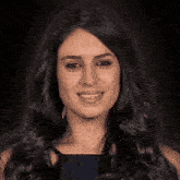 a close up of a woman 's face with long black hair smiling .