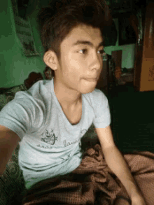 a young boy wearing a gray shirt with a cartoon character on it