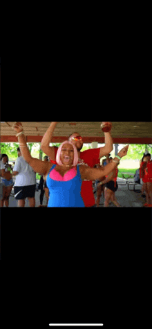 a man and a woman are posing for a picture with their arms in the air