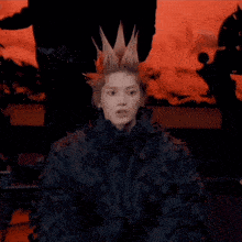 a person with a crown on their head is making a surprised face