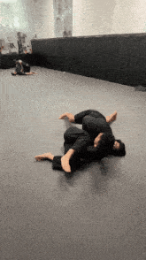 a group of people are practicing martial arts on a mat in a gym