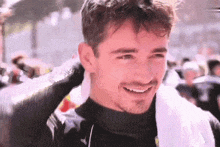 a close up of a man with a towel around his neck smiling .